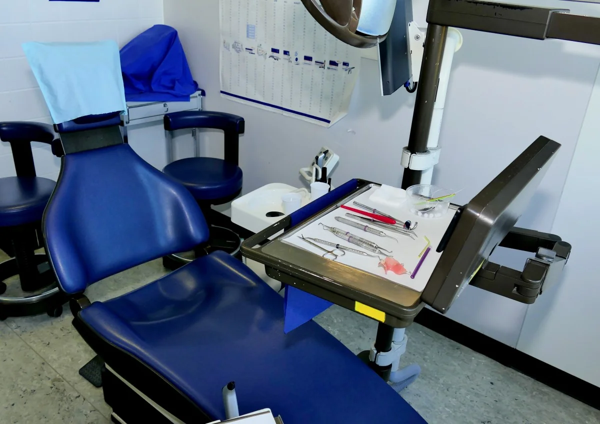 Dental treatment chair with an examination light and instrument tray.