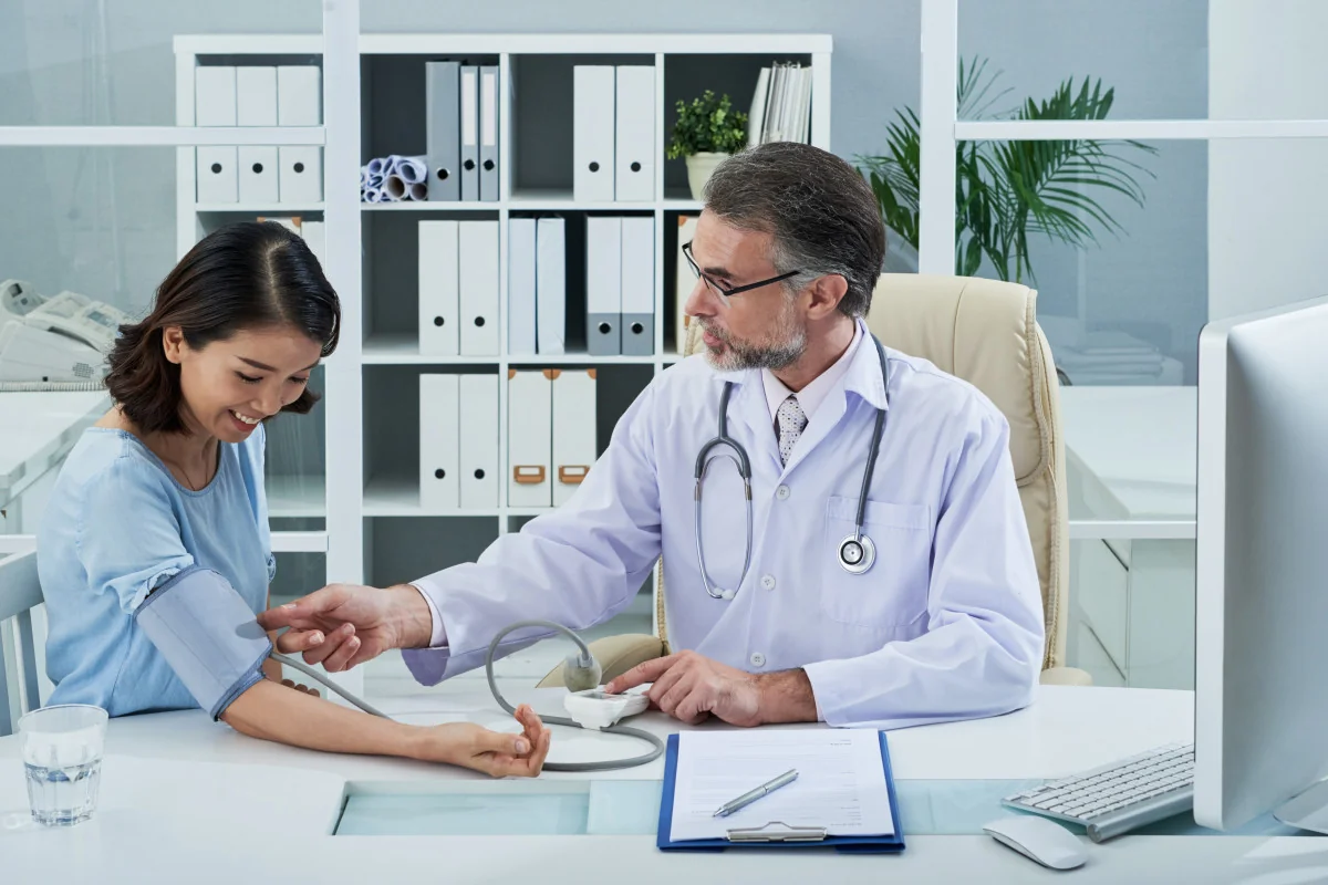 Healthcare professional checking a patient’s blood pressure.