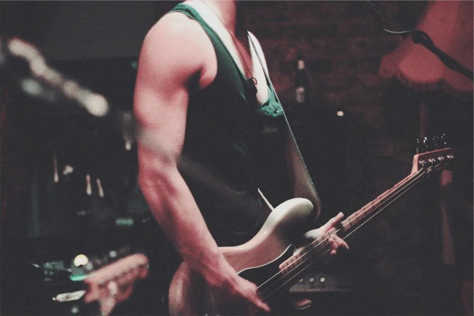 Musician playing an electric guitar during a performance.