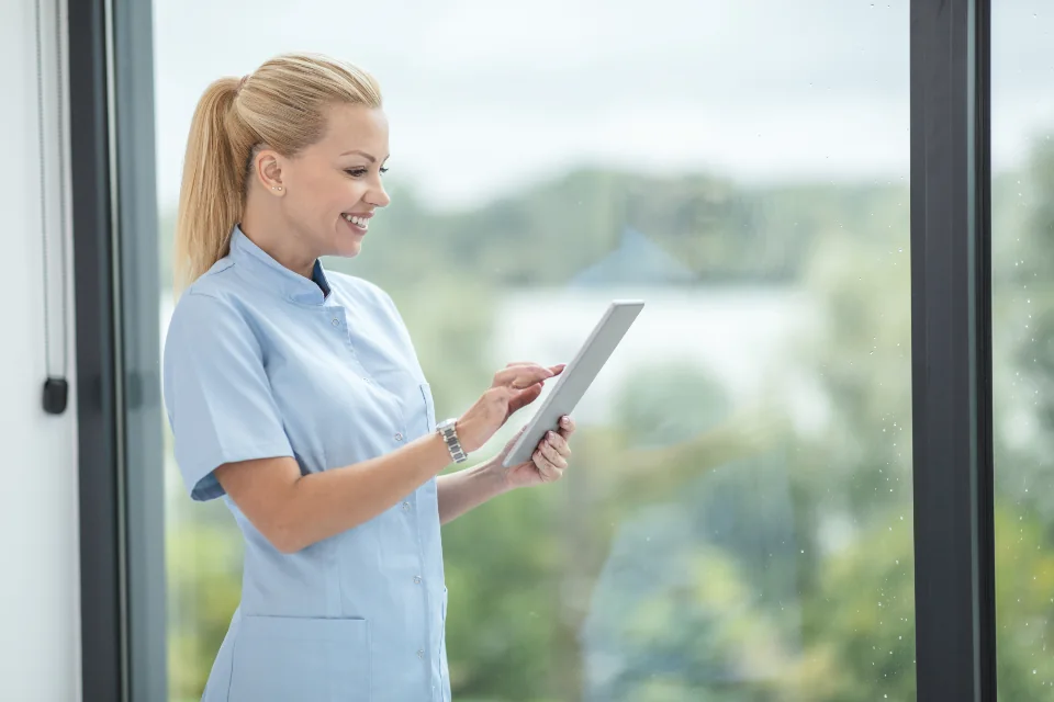Healthcare professional using a tablet in a bright clinic.