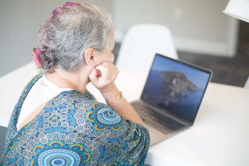 Adult studying information on a laptop.